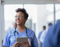 nurse holding tablet and smiling