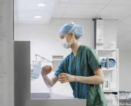 nurse with mask washing hands